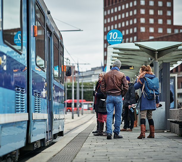 Reisende på trikkeperrongen. Rådhuset i bakgrunnen.
